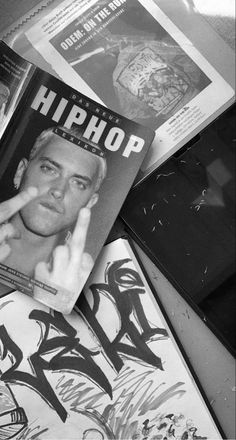 an old photo of a man making the v sign with his hand and some books