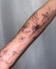 a person's arm with tattoos on it and flowers in the middle of their arm