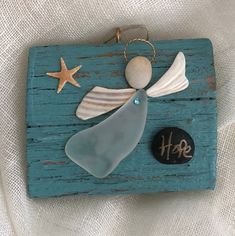 a blue wooden plaque with an angel and starfish on it