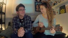 a man and woman sitting next to each other playing ukulele guitares in their living room