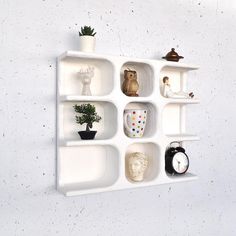 a white shelf filled with different types of vases and other decorative items on top of it