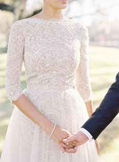 the bride and groom hold hands as they walk together