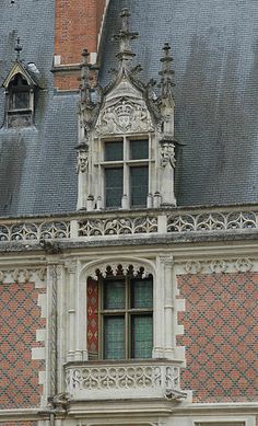 an old building with a clock on it's side and windows above the door