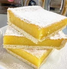 three pieces of cake sitting on top of a white plate with powdered sugar around them