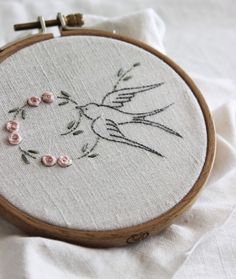 a close up of a embroidery on a piece of cloth with flowers and a bird