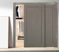 an open closet door with clothes on hangers and other items in the room next to it