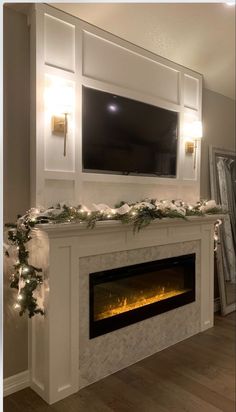 the fireplace is decorated with christmas garland and lights