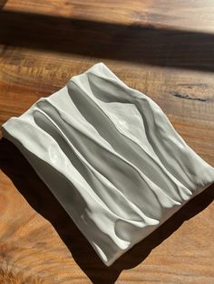 a white ceramic dish sitting on top of a wooden table