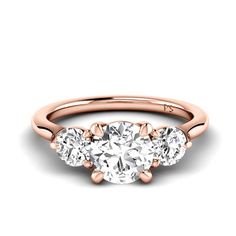 three stone engagement ring in rose gold with diamonds on the sides and an oval diamond center