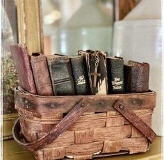 a wooden basket filled with books on top of a table