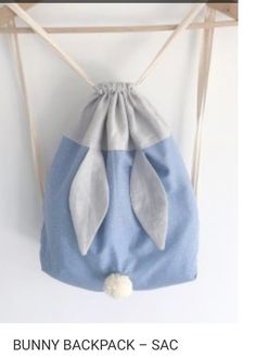 the bunny backpack - sac is hanging from a wooden hanger with two ears on it