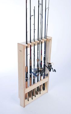 a wooden rack with fishing rods and reels in it on a white background,