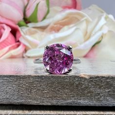 "This ring pictured is lab created pink sapphire #6465 -Approximate total carat weight: 2.70ctw. diamond equivalent -Center Stone Size: 9mm - approx. 2.70ct diamond equivalent -Center Stone Shape: Round -Gem Type: Lab Created Sapphire -Stone Clarity: VS2 -Stone Color: Medium Pink -Moh's Scale: 9 hardness -Metal Type and Purity: 14k White or Yellow Gold -Setting: Tulip 4 Prong Setting -Stock Ring Size: 6 -Country of Manufacturing: USA (Michigan) For customization please contact us. If you have an Pink Brilliant Cut Amethyst Wedding Ring, Wedding Pink Brilliant Cut Amethyst Ring, Pink Brilliant Cut Sapphire Ring In Fine Jewelry Style, Pink Diamond Amethyst Ring In Fine Jewelry Style, Pink Brilliant Cut Sapphire Ring Fine Jewelry, Classic Pink Amethyst Wedding Ring, Pink Diamond Ring With Round Band In Fine Jewelry, Pink Round Diamond Ring, Fine Jewelry, Classic Pink Ruby Ring With Accent Stones