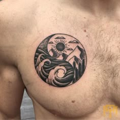 a man's chest with a mountain and sun tattoo on it