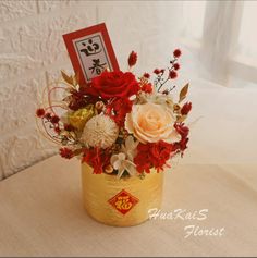 a vase filled with flowers sitting on top of a table next to a card holder