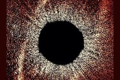 an eyeball is shown in the center of a black and red background with white dots