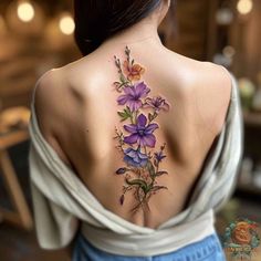 a woman's back tattoo with purple flowers on her left shoulder and lower back