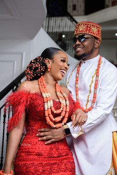 a man and woman standing next to each other in front of some stairs with beads on them