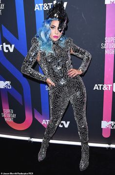 lady with blue hair and silver bodysuit posing on the red carpet at an event