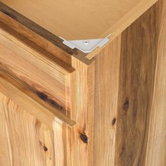 a close up of a wooden cabinet door with an electronic device in the bottom drawer