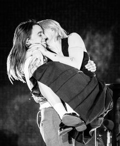 two people kissing each other on stage