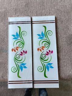 two white tiles with colorful flowers on them