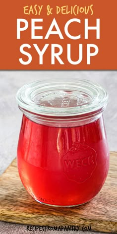 a jar filled with peach syrup on top of a wooden cutting board