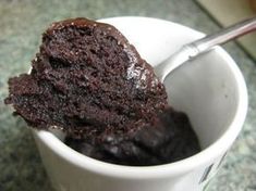 a close up of a spoon in a cup filled with cake