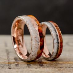 two wedding bands with antler wood inlays are on top of each other