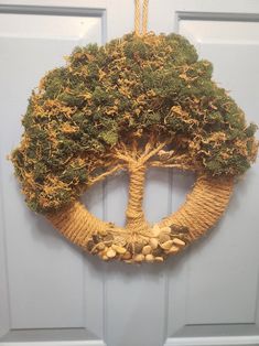 a door hanger with a tree made out of rope and nuts hanging from it