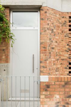 a white door and gate in front of a brick building