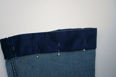 the back side of a pair of jeans with pins sticking out of it's pockets