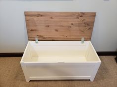 a white chest with wooden headboard and handles