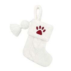 a white christmas stocking with a red paw on it and a tassel hanging from the side