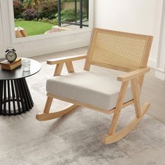 a wooden rocking chair sitting on top of a carpeted floor next to a window