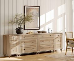 a large wooden dresser sitting in a living room next to a chair and table with vases on it