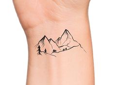 a small mountain tattoo on the wrist