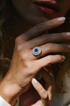 a woman wearing a diamond and sapphire ring