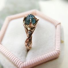 a close up of a ring in a box on a white surface with pink velvet