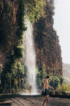 a man standing in front of a waterfall