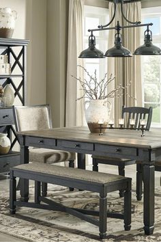 a dining room table with two chairs and a bench