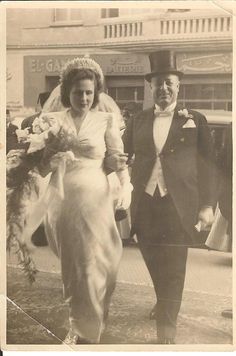 an old photo of a man and woman walking down the street