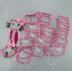 hello kitty crochet kits and accessories are displayed on a gray surface with pink trim