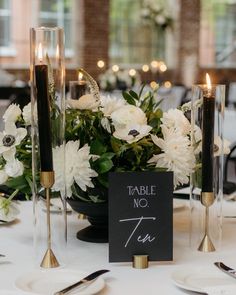 the table is set with white flowers and candles