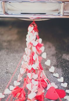 red and white hearts on the ground next to a car