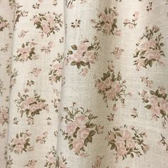 a close up view of a flowered curtain with pink flowers and green leaves on it