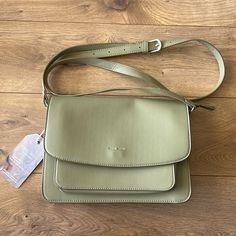 This Timeless Everyday Crossbody Bag Can Be Easily Styled Up Or Down. -Outside Pocket For Easy Phone / Keys Access. -Zip Top -Adjustable Strap. This Beauty Is Both Form And Function, With Pockets For Days, High-End Metallic Detailing, A Magnetic Button Closure On The Fold Over Flap & A Detachable Strap. It’s Made From Vegan Leather & Features An Inner Lining Created With Recycled Bottles. Available In Sage And Is Brand New, Never Carried With Tags Attached! Retails At $80. Dimensions: 10.25 X 7. Green Square Flap Bag For Everyday Use, Green Square Flap Bag For Everyday, Everyday Green Square Flap Bag, Green Saddle Bag With Removable Pouch, Everyday Green Saddle Bag With Removable Pouch, Green Saddle Bag With Removable Pouch For Everyday, Green Rectangular Flap Bag For Everyday Use, Green Travel Saddle Bag With Removable Pouch, Green Satchel With Adjustable Handle For Everyday