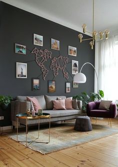 a living room with grey walls and pictures on the wall above the couch is a coffee table