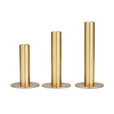 three brass candlesticks are standing in front of each other on a white background