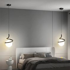 a bed with two lights hanging from the ceiling above it and a night stand next to it